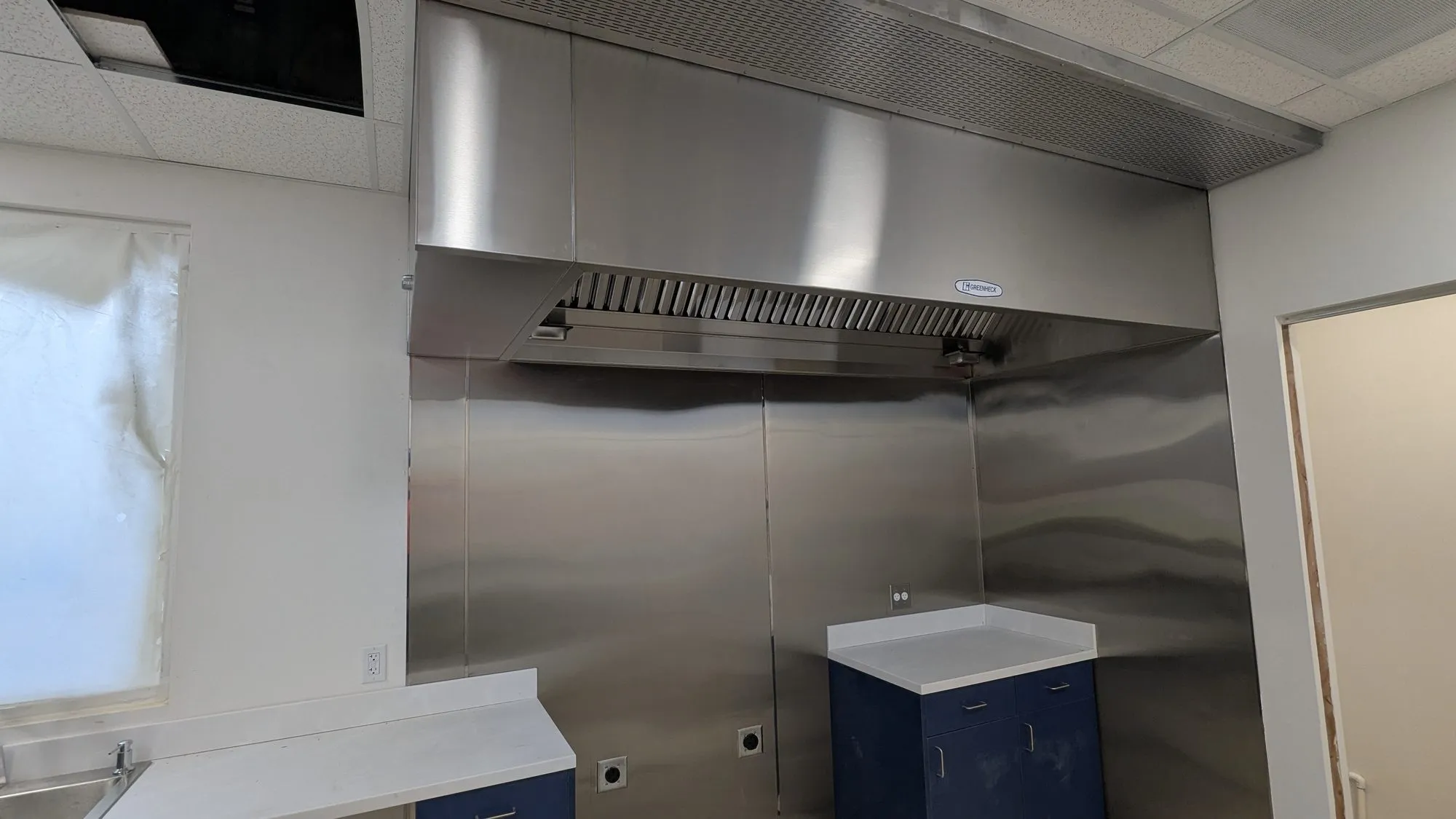 A stainless steel exhaust hood in a commercial kitchen
