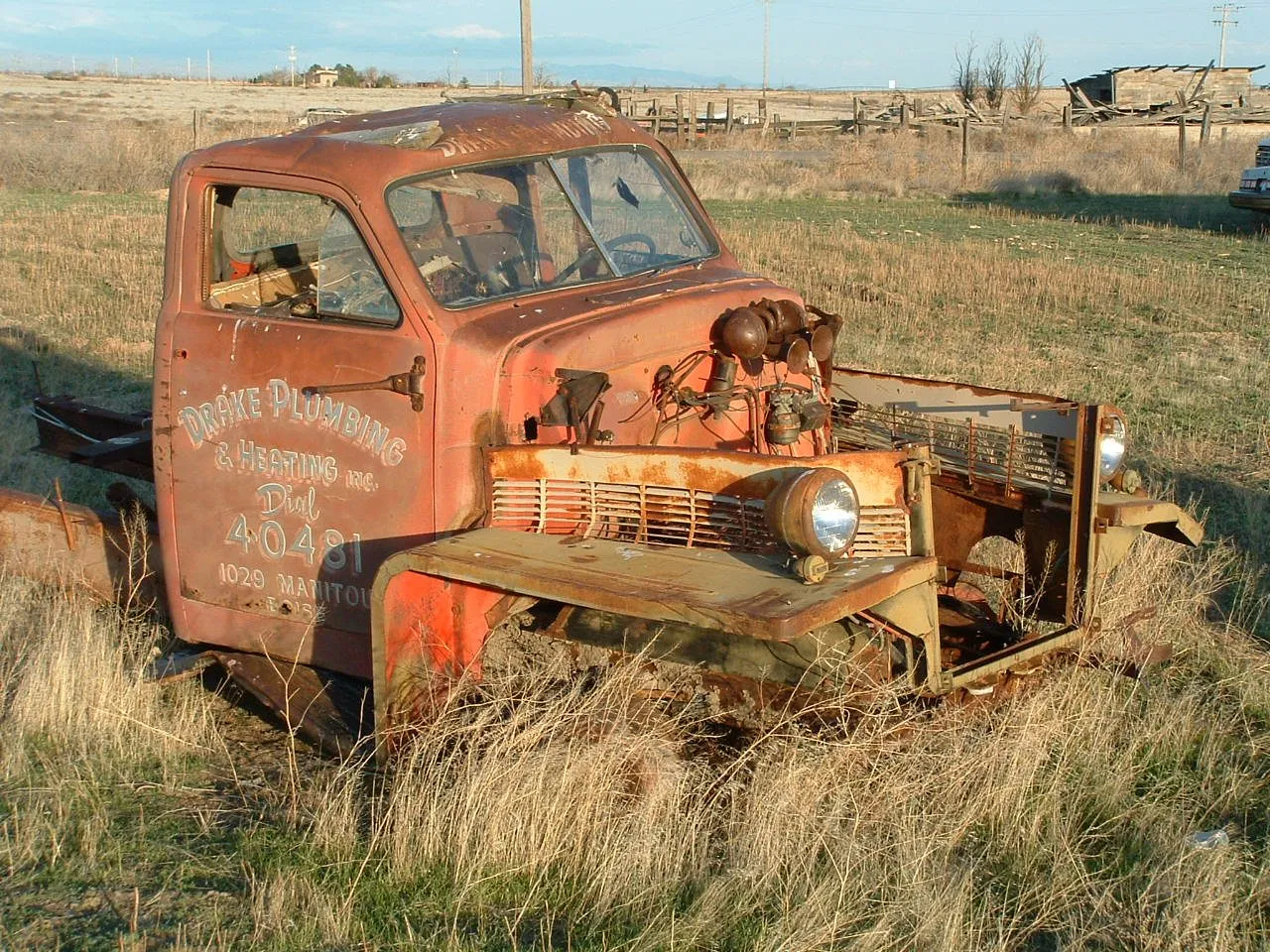 A weathered old truck lettered Drake Plumbing & Heating Inc., Dial 4-0481
