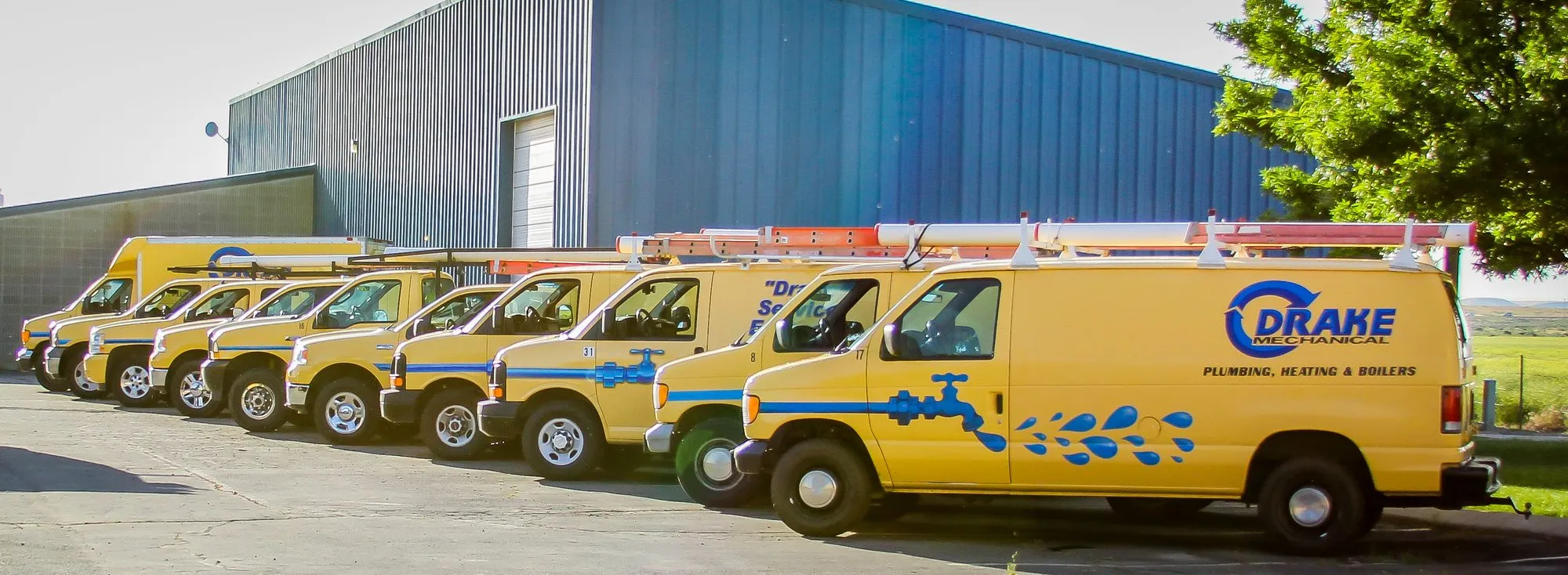 A row of yellow Drake Mechanical service vans