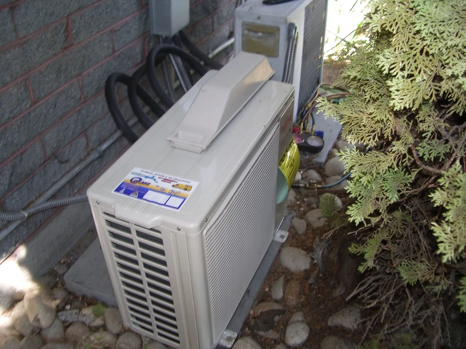 A ductless mini-split outdoor unit beside a house