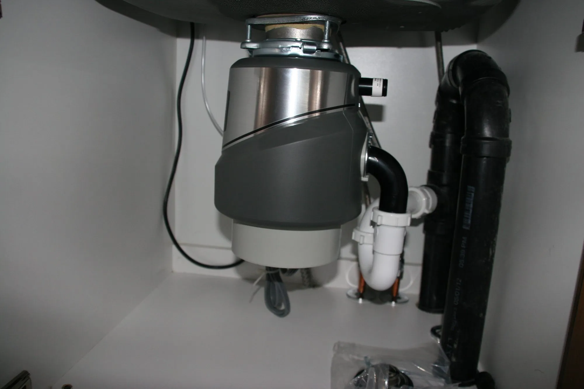 A garbage disposal installed under a kitchen sink