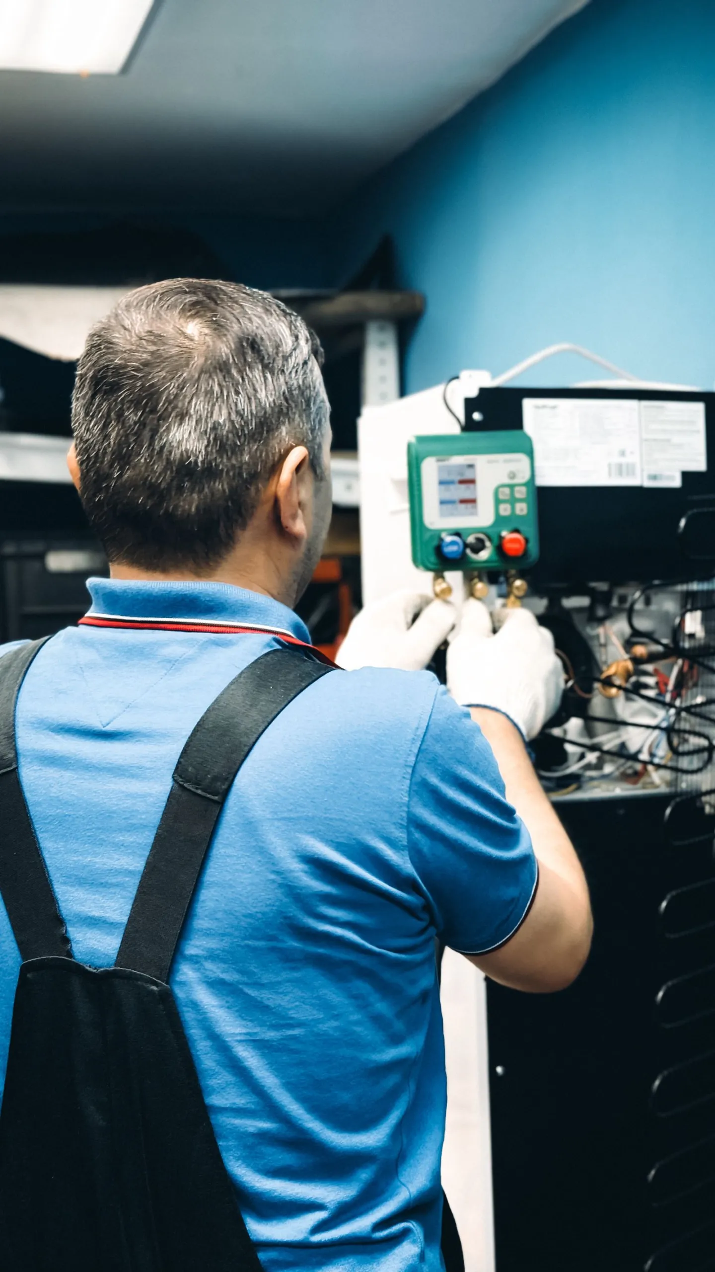 Technician testing an HVAC control board with a meter
