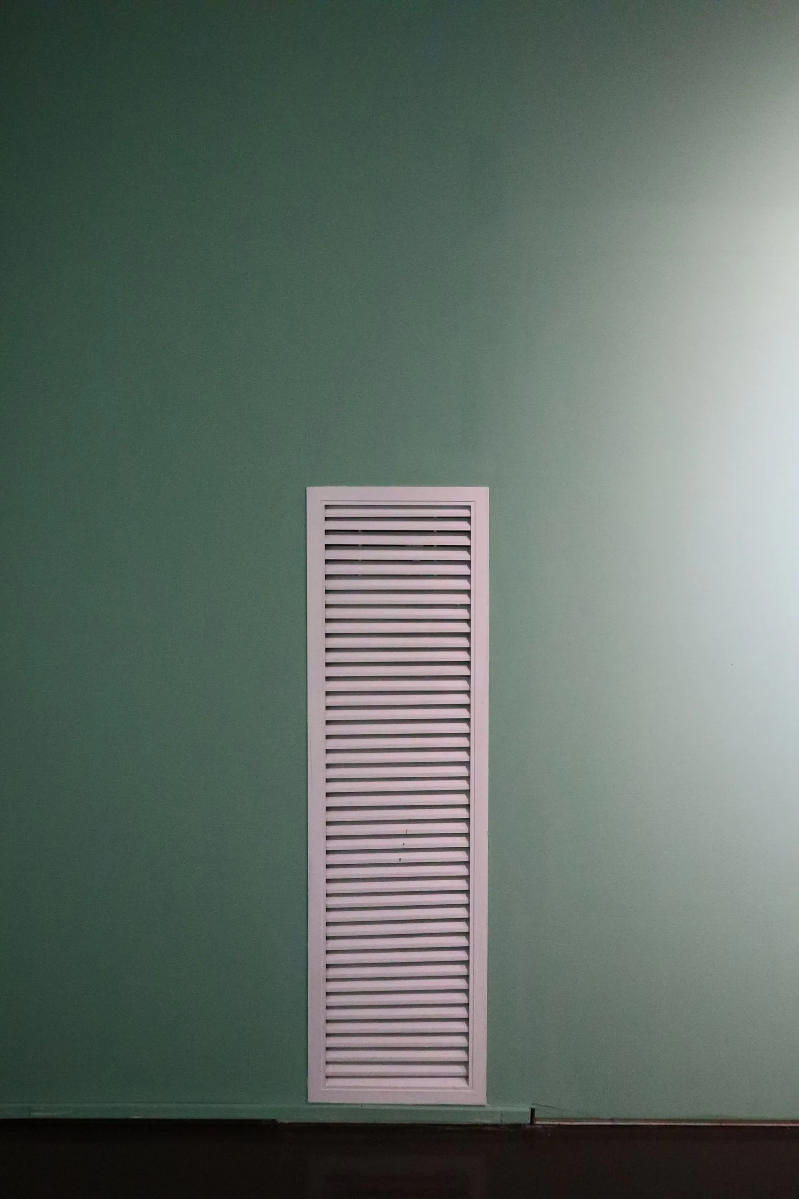 Ventilation grille on a green wall