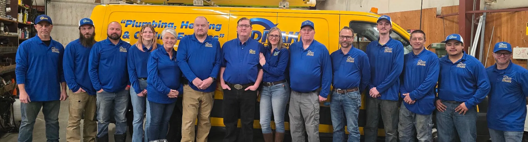 The Drake Mechanical team in front of a yellow Drake van